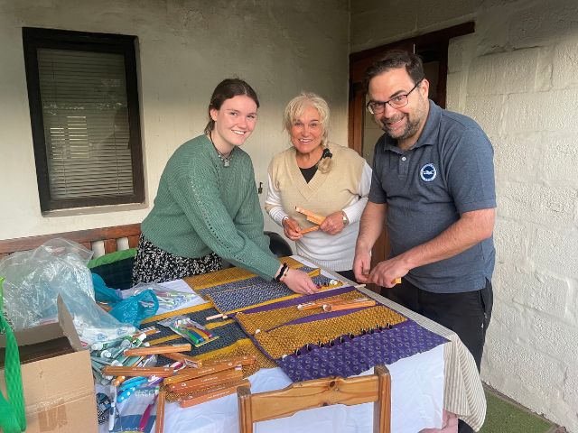 three people outside volunteer green shirt